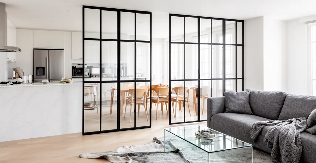 Verrière en acier noir séparant une cuisine d'un salon lumineux